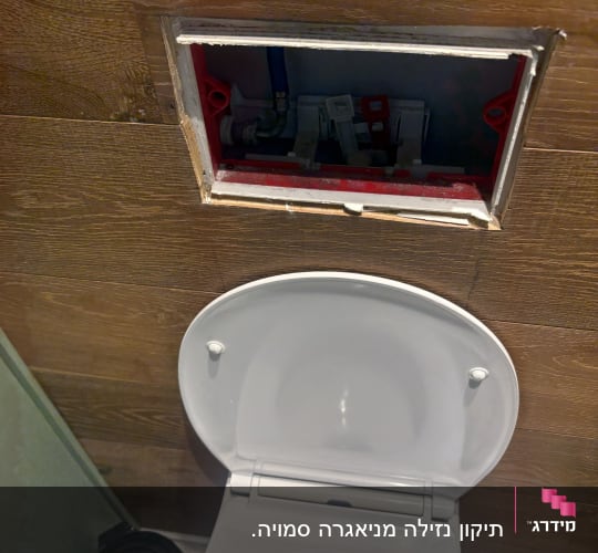 אסלה עם פתח גישה לצנרת בקיר עץ